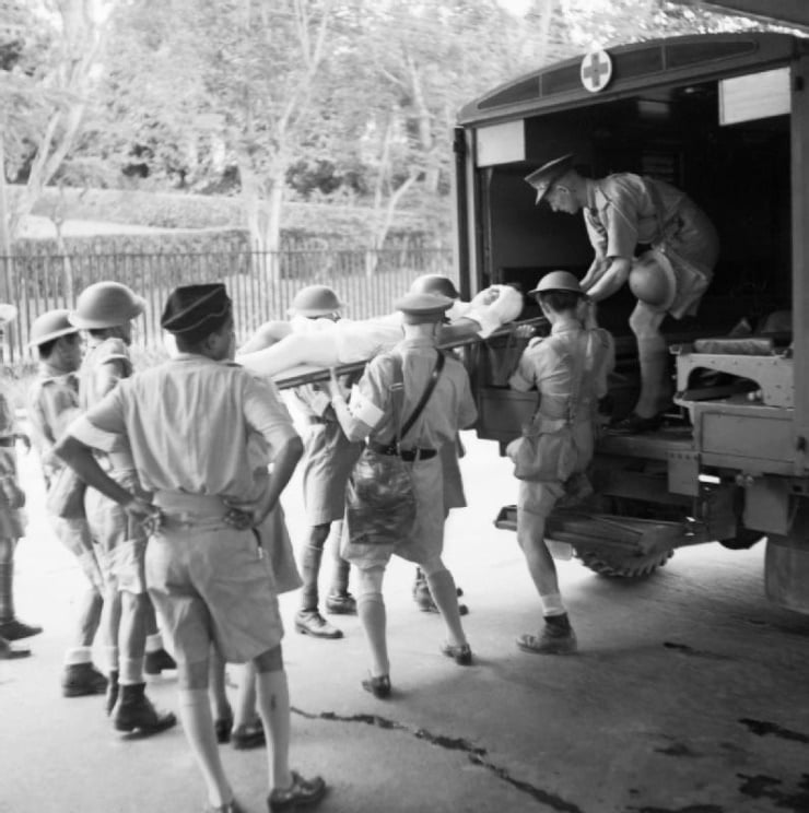 A casualty from the battle area being put into an ambulance on arrival at Singapore.