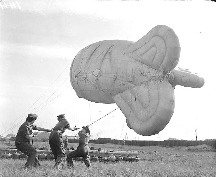 WAAFs hauling in a kite balloon at a coastal site.