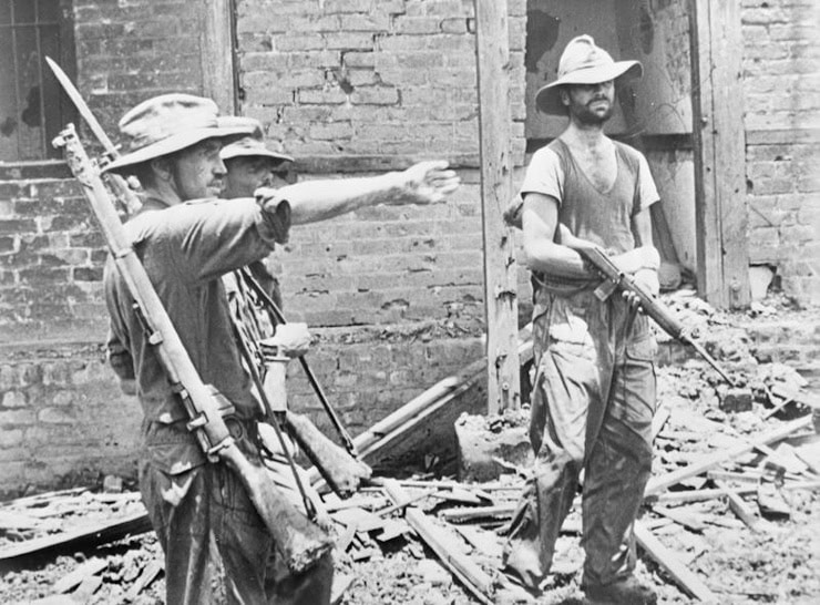 Brigadier "Mad" Mike Calvert (left) gives orders to Lieutenant-Colonel Shaw, while Major James Lumley stands with M1 carbine under his arm, after the capture of Mogaung in Burma during the second Chindit expedition, June 1944. WC.