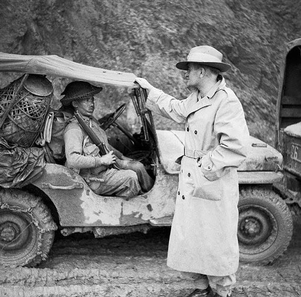 Lieutenant General Sir William Slim, commanding British Fourteenth Army in Burma, chatting with a Gurkha rifleman, Palel area, Burma, November 1944. PD. WC.